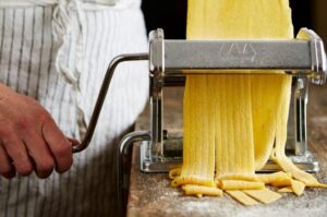 Simple rolling out pasta dough with semolina flour in a machine