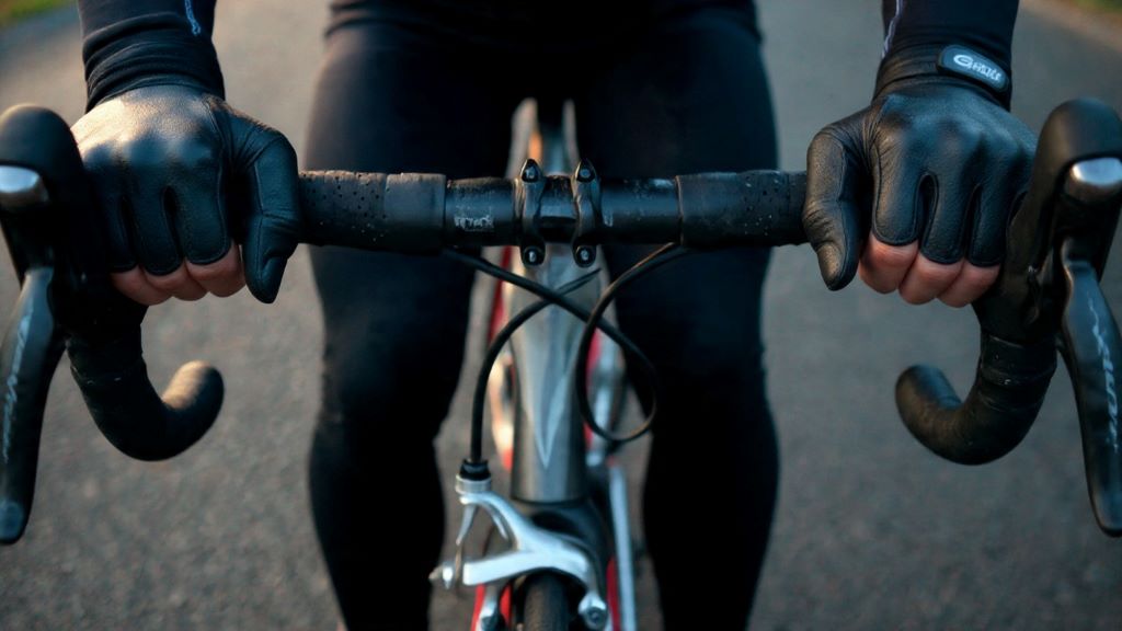 2. Close-up of cyclist wearing padded gloves gripping bicycle handlebars for comfort