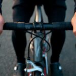 1. Cyclist adjusting handlebar grip position to prevent hand numbness during long ride