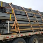 Flatbed trailer with steel cargo secured using blocking and bracing systems with tie-down straps