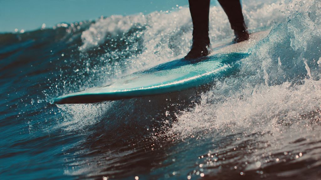 Close-up view of surfboard leaving wave face during chop hop technique showing proper body positioning and balance