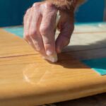 Damaged surfboard tail block showing crack and delamination requiring fiberglass repair