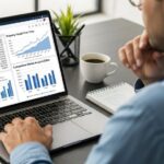 Real estate investor analyzing cap rate calculations and property valuation charts on laptop screen