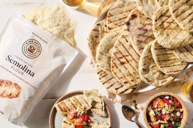 Close-up of semolina flour being mixed into pizza dough for better flavor and crunch.