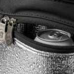 Modern golf bag with insulated cooler pocket open showing cold beverages inside on golf course