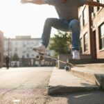 Skateboarder executing a kickflip using Independent trucks and Spitfire wheels on urban street