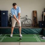 Golfer practicing swing on portable foldable golf practice mat in home garage with alignment guides visible