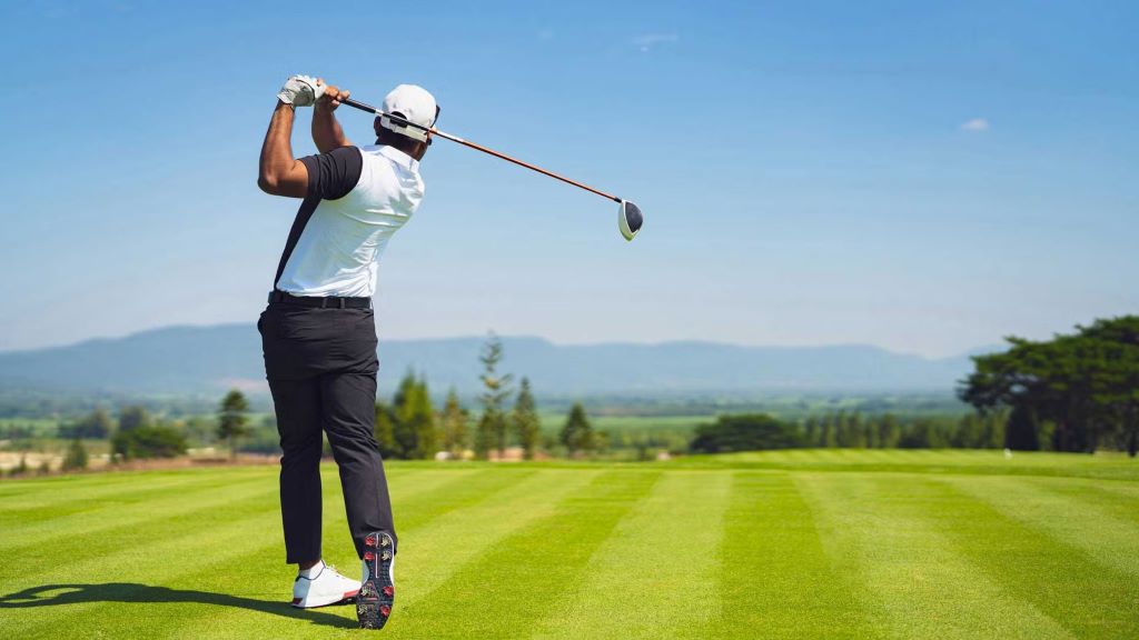 Golfer adjusting hand position on golf club for better swing control